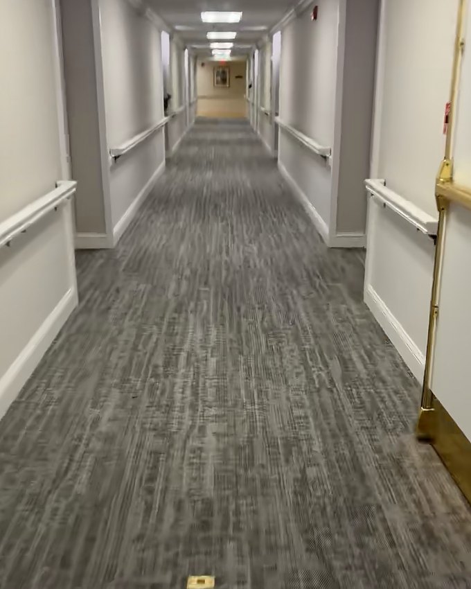 After: the same facility corridor at the fire doors with new carpet down